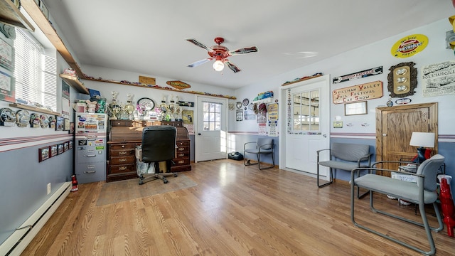 office space with a baseboard heating unit, light hardwood / wood-style floors, and ceiling fan