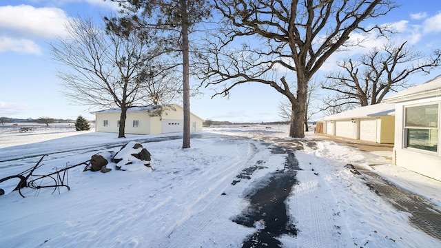 yard covered in snow featuring a garage