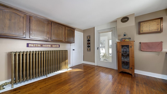 interior space with radiator heating unit and dark hardwood / wood-style floors