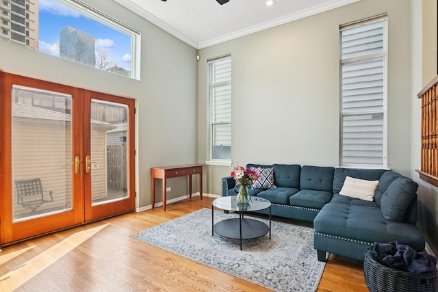 living room with ceiling fan, baseboards, ornamental molding, french doors, and wood finished floors