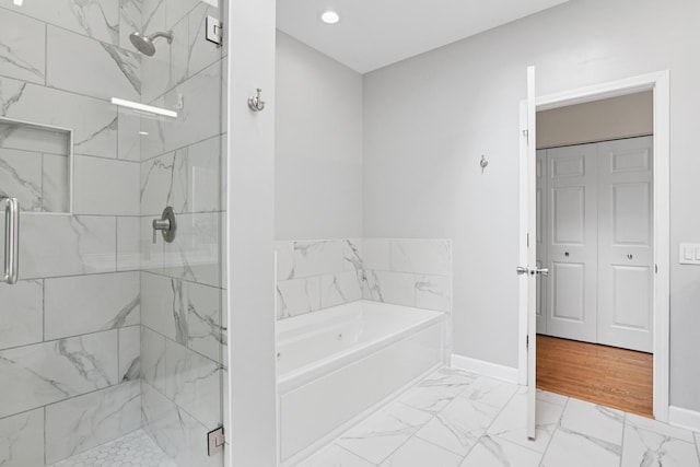 bathroom with a marble finish shower, marble finish floor, a bath, and baseboards