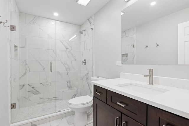 bathroom with vanity, toilet, marble finish floor, and a stall shower