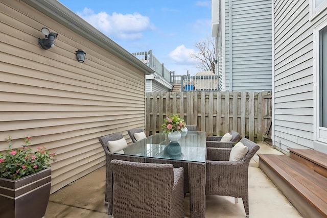 view of patio with outdoor dining area and fence