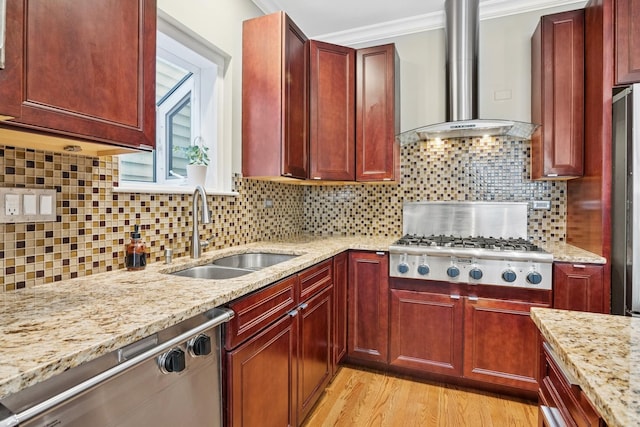 kitchen featuring a sink, appliances with stainless steel finishes, crown molding, wall chimney range hood, and reddish brown cabinets