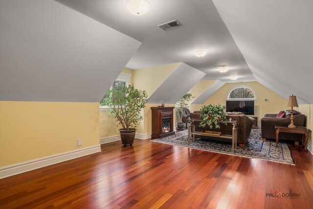 additional living space with dark wood-type flooring and vaulted ceiling