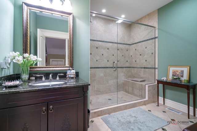 bathroom with tile patterned flooring, vanity, and walk in shower