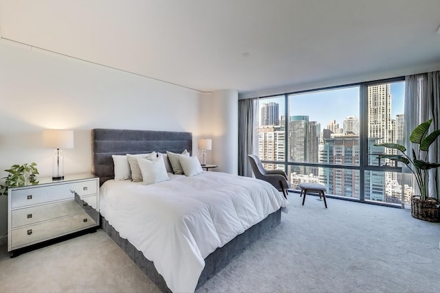 carpeted bedroom featuring a view of city and expansive windows