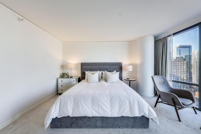 bedroom with a view of city, carpet flooring, and baseboards