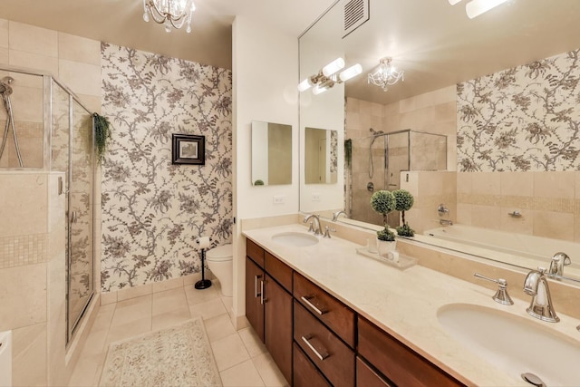 bathroom with wallpapered walls, a shower stall, tile patterned flooring, and a sink