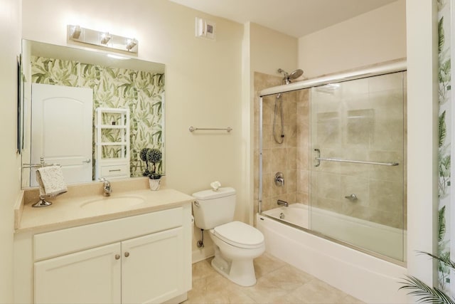 bathroom with vanity, visible vents, bath / shower combo with glass door, tile patterned flooring, and toilet