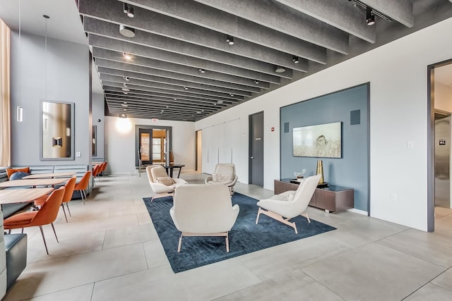 living room with beamed ceiling and rail lighting