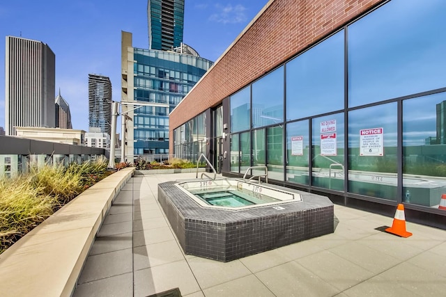 view of pool featuring a city view and a hot tub