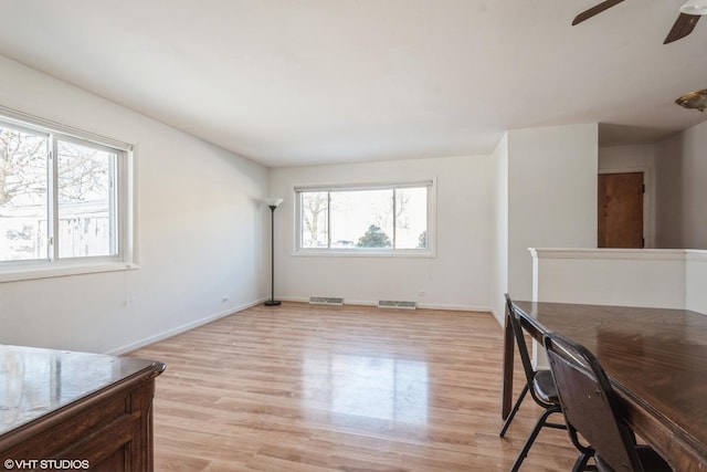 interior space with baseboards, visible vents, ceiling fan, and light wood-style flooring