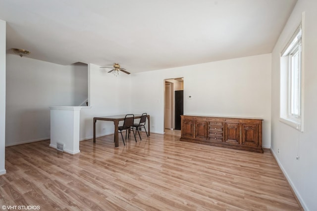 spare room featuring baseboards, ceiling fan, light wood finished floors, and visible vents