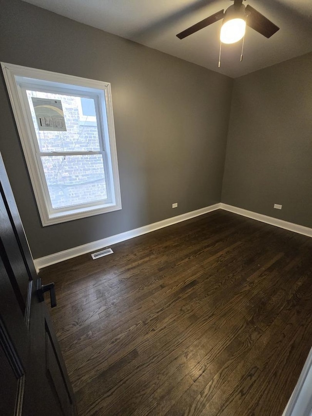 2040 W Garfield Blvd, Chicago, IL 60609 - unfurnished room with dark wood finished floors, baseboards, visible vents, and a ceiling fan