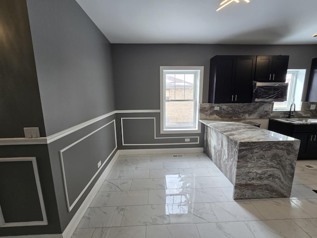 2040 W Garfield Blvd, Chicago, IL 60609 - kitchen with wainscoting, dark cabinetry, a decorative wall, marble finish floor, and a sink