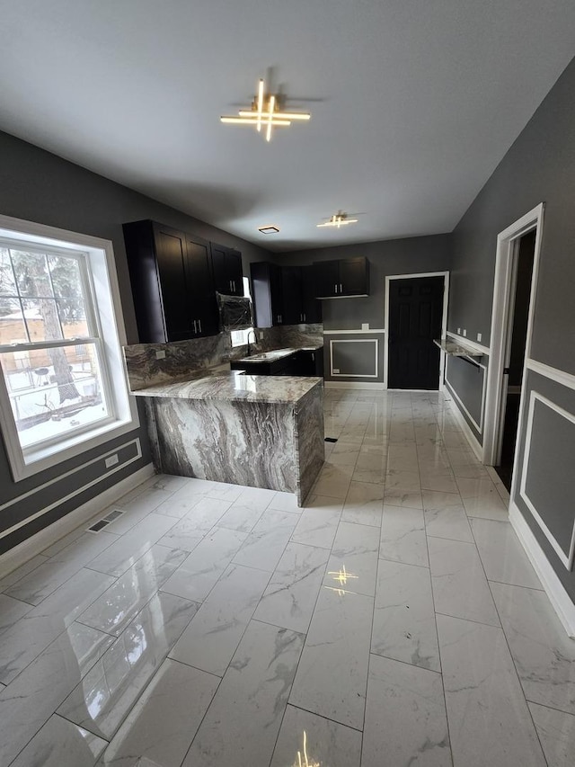 2040 W Garfield Blvd, Chicago, IL 60609 - kitchen featuring visible vents, light stone countertops, a peninsula, marble finish floor, and dark cabinets