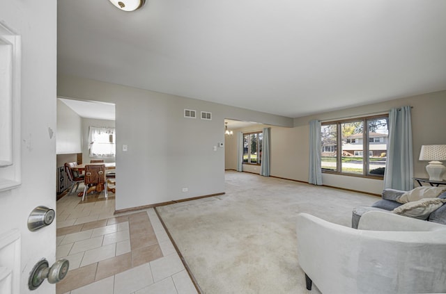 living room with a healthy amount of sunlight, light tile patterned floors, and an inviting chandelier