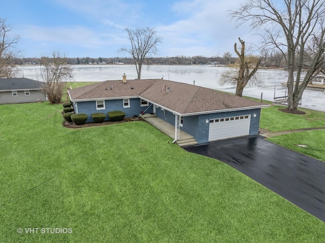 ranch-style house with a garage, a water view, driveway, and a front lawn