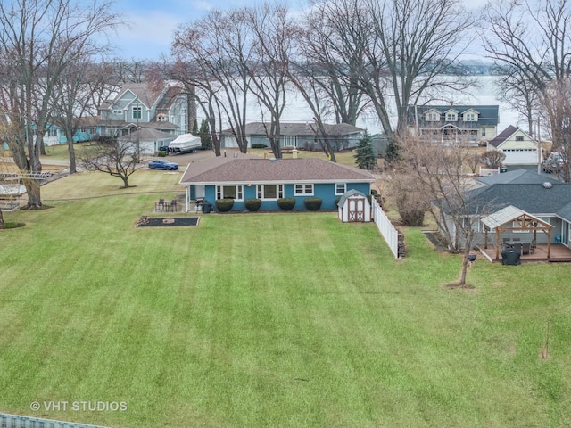 view of front facade with an outbuilding, a residential view, a front lawn, and a shed