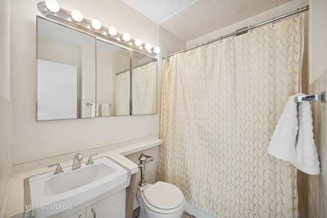 full bathroom with curtained shower, a sink, and toilet