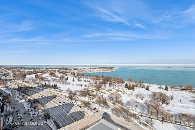 snowy aerial view featuring a water view