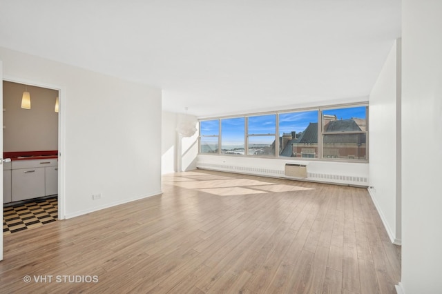 unfurnished living room with light wood-style floors and baseboards