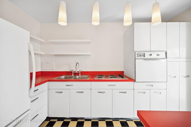 kitchen featuring white appliances, a sink, white cabinetry, hanging light fixtures, and tile patterned floors