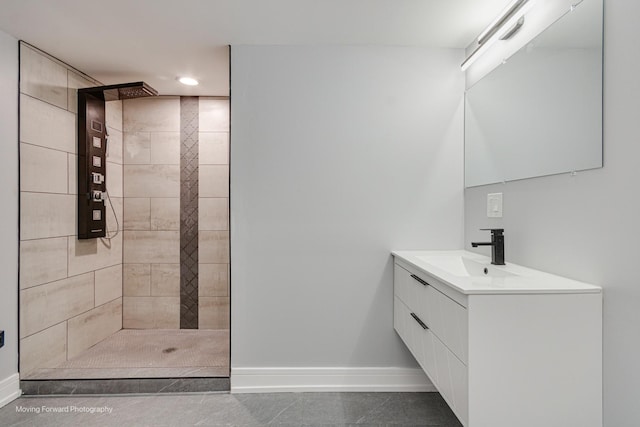 bathroom featuring a tile shower, vanity, and tile patterned flooring