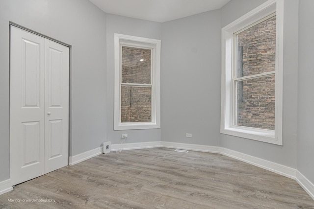 empty room with a wealth of natural light and light wood-type flooring