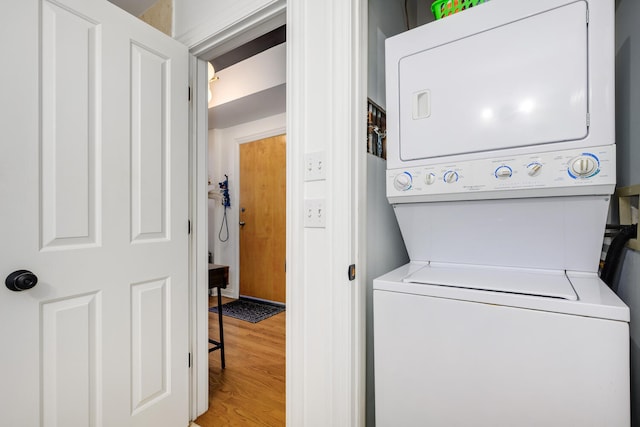 washroom featuring stacked washer / dryer and hardwood / wood-style flooring