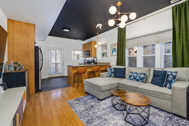 living room with light wood-type flooring and an inviting chandelier