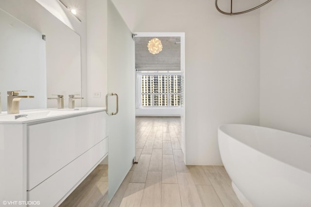 bathroom featuring vanity and a washtub