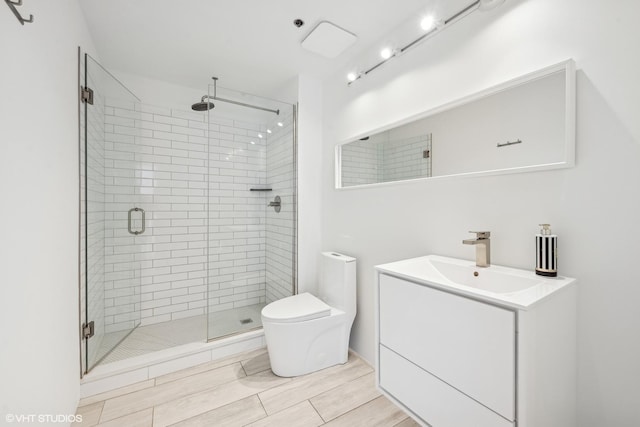 bathroom with vanity, an enclosed shower, and toilet