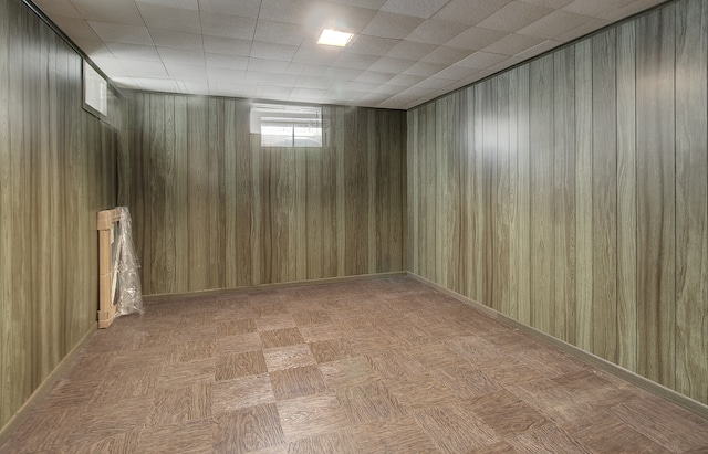 basement featuring wooden walls