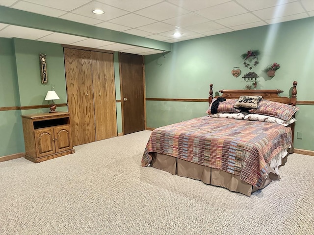 bedroom featuring carpet and a drop ceiling