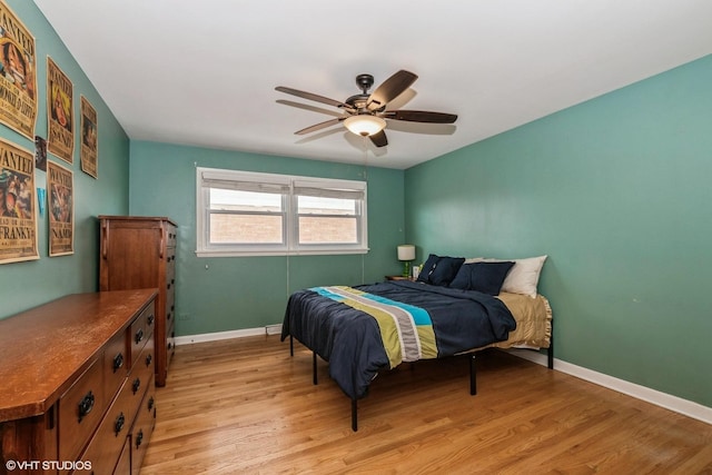 bedroom featuring baseboards, light wood finished floors, and ceiling fan