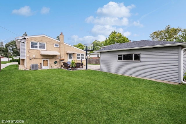 rear view of house with central AC, a patio area, a lawn, fence, and brick siding