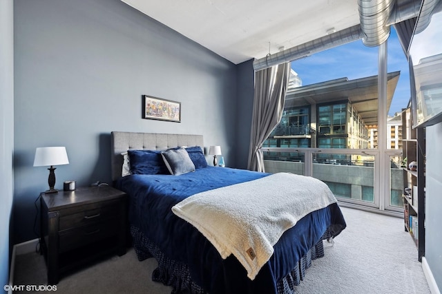 bedroom with carpet floors and a wall of windows