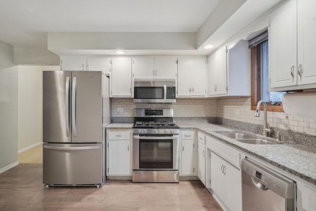 kitchen with white cabinetry, appliances with stainless steel finishes, sink, and light hardwood / wood-style flooring