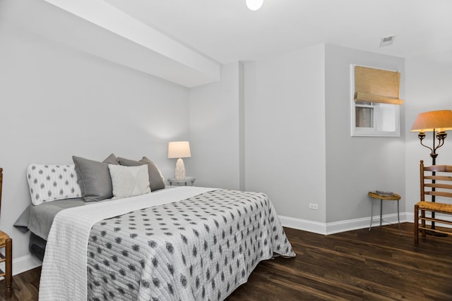 bedroom featuring visible vents, baseboards, and wood finished floors