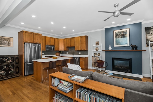 kitchen with stainless steel appliances, a center island, light countertops, and wood finished floors