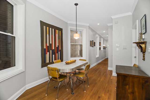 dining area featuring ornamental molding, baseboards, and wood finished floors