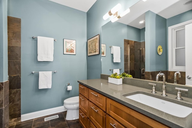 bathroom with baseboards, visible vents, toilet, a tile shower, and vanity