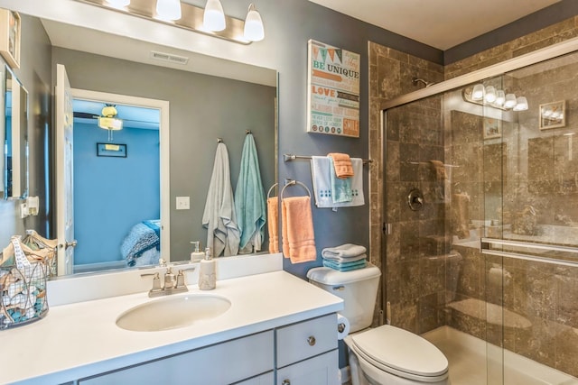 bathroom with vanity, a shower with door, and toilet