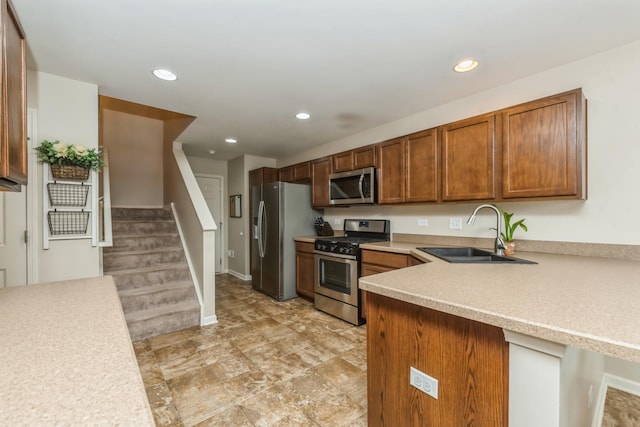 kitchen with appliances with stainless steel finishes, sink, and kitchen peninsula