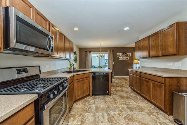 kitchen with pendant lighting, sink, appliances with stainless steel finishes, an inviting chandelier, and kitchen peninsula