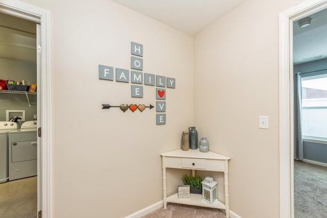 corridor featuring light colored carpet and washer and clothes dryer