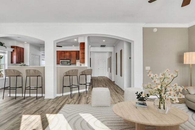 living area with recessed lighting, visible vents, a ceiling fan, light wood-type flooring, and crown molding