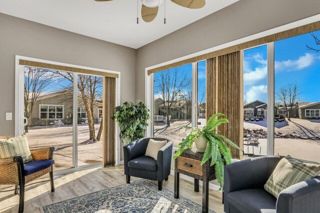 living area featuring a residential view, ceiling fan, and light wood finished floors